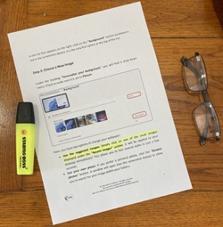 Printed PC guides for beginners and seniors with large text and screenshots, placed on a wooden desk next to reading glasses and a highlighter.